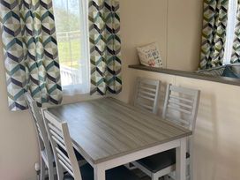 A dining area with a table and chairs at Caravan in Holcot Sleeps 6 Max 6 people Max 4 adults per booking Pet Friendly Holcot near Moulton