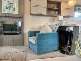 A living room with a chair and television at Caravan in Holcot Sleeps 6 Max 6 people Max 4 adults per booking Pet Friendly Holcot near Moulton