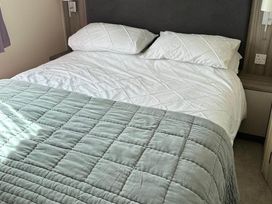A bedroom with a bed and pillows at Caravan in Holcot Sleeps 6 Max 6 people Max 4 adults per booking Pet Friendly Holcot near Moulton