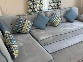 A sofa with cushions in a living room at Caravan in Holcot Sleeps 6 Max 6 people Max 4 adults per booking Pet Friendly Holcot near Moulton