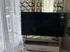 A television on a stand with a remote control in the living room at Caravan in Holcot Sleeps 6 Max 6 people Max 4 adults per booking Pet Friendly Holcot near Moulton