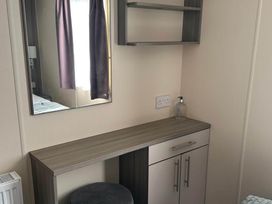A bedroom with a mirror and a small desk at Caravan in Holcot Sleeps 6 Max 6 people Max 4 adults per booking Pet Friendly Holcot near Moulton