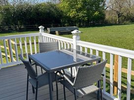 A table and chairs on a deck area at Caravan in Holcot Sleeps 6 Max 6 people Max 4 adults per booking Pet Friendly in Holcot near Moulton