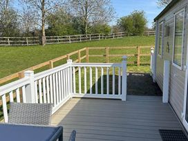 A deck with a mobile home and a fence at Caravan in Holcot Sleeps 6 Max 6 people Max 4 adults per booking Pet Friendly Holcot near Moulton
