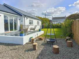 A garden with a deck, chairs, and a swing at Aberporth 2 Bed Cottage Sleeps 4 Pet Friendly Parcllyn near Aberporth