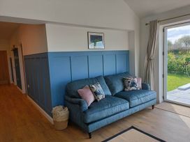 A living room with a blue sofa and a door leading to the garden at Aberporth 2 Bed Cottage Sleeps 4 Pet Friendly Parcllyn near Aberporth