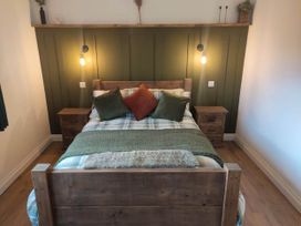 A bedroom with a wooden bed and bedside tables at Aberporth 2 Bed Cottage Sleeps 4 Pet Friendly Parcllyn near Aberporth