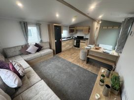 A living room with a sofa and dining area at 8 Guests Swimming Pool 1min to the Beach Heacham