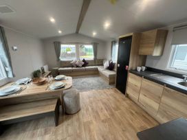 A living room with a sofa and dining area at 8 Guests Swimming Pool 1min to the Beach Heacham