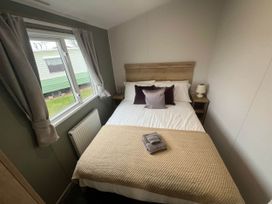 A bedroom with a bed and window at 8 Guests Swimming Pool 1min to the Beach Heacham