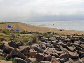 A beach with rocks and water at 8 Guests Swimming Pool 1min to the Beach Heacham