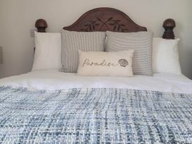 A bed with pillows and a decorative pillow at Looe Cottage Seaside views log fire sleeps 4 in Looe