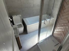 A bathroom with a bathtub and shower at Looe Cottage Seaside views log fire sleeps 4 in Looe