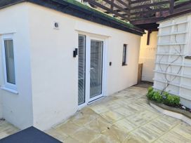 An outdoor area with a glass door and windows at Conwy Charm Cottage 3 Bed Retreat Penmaenmawr