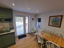 A kitchen with a dining table and sliding doors at Conwy Charm Cottage 3 Bed Retreat in Penmaenmawr