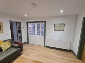 A living room with a sofa and a front door at Conwy Charm Cottage 3 Bed Retreat Penmaenmawr