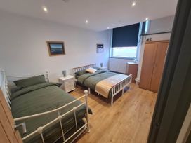 A bedroom with two beds and a wardrobe at Conwy Charm Cottage 3 Bed Retreat Penmaenmawr