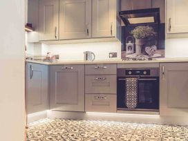 A kitchen with cabinets, an oven, a kettle, and a sink at 3Bed Cottage Plymouth Dog friendly Sleeps7 in Plymouth