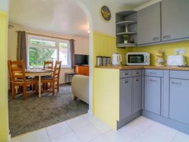 A kitchen with appliances and a dining area at 2 Bed Cottage Sleeps 4 Pets Parking Wifi Near Liskeard