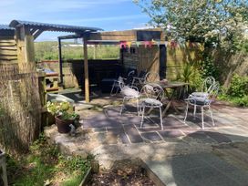 An outdoor seating area with a table and chairs at The Owl House in countryside setting near Niwbwrch (newborough)