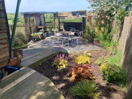 A garden with a patio area and seating at The Owl House in countryside setting near Niwbwrch (newborough)