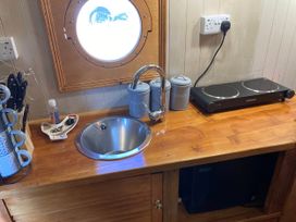 A kitchen with a sink and electric stove at The Owl House in countryside setting near Niwbwrch (newborough)