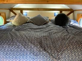 A bed with pillows in a loft at The Owl House in countryside setting near Niwbwrch (newborough)