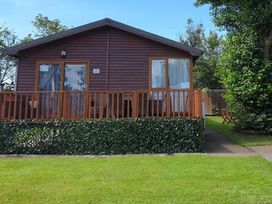 A cabin with a deck and pathway at The Old Barn in Fleetwood