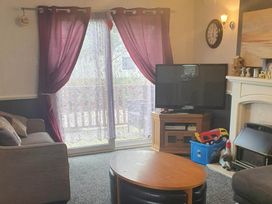 A living room with a television and sofa at The Old Barn in Fleetwood