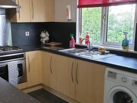 A kitchen with an oven, stove, sink, and washing machine at The Old Barn in Fleetwood