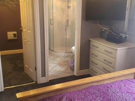 A bedroom with a dresser and a bathroom featuring a shower at Fleetwood
