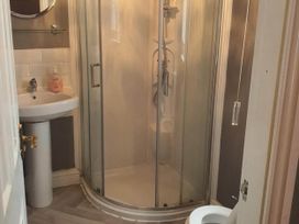 A bathroom with a shower, wash basin, and toilet at 