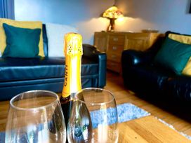 A living room with a champagne bottle and glasses at The Old Barn in Tanygrisiau near Blaenau Ffestiniog