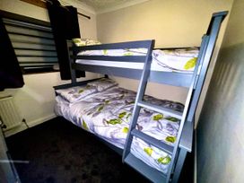 A bedroom with a bunk bed and bedding at Tanygrisiau near Blaenau Ffestiniog