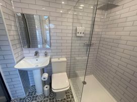 A bathroom with a shower, toilet, sink and mirror at Tanygrisiau near Blaenau Ffestiniog