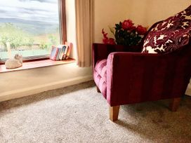 A living room with an armchair and a window at Tanygrisiau near Blaenau Ffestiniog