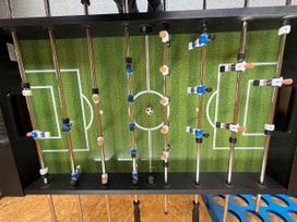 A foosball table with players and a ball in a recreation room at Tanygrisiau near Blaenau Ffestiniog