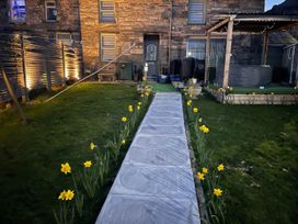 A garden with a stone house, pathway, and flowers at Tanygrisiau near Blaenau Ffestiniog