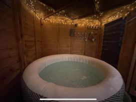 A hot tub in a wooden structure with lights at Tanygrisiau near Blaenau Ffestiniog