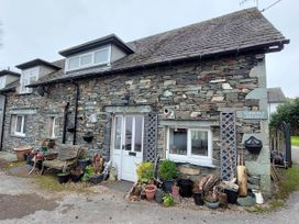 A stone cottage with plants outside at Fairfield Cottage in Hawkshead