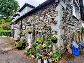 An outdoor area with flower pots and a stone cottage at Fairfield Cottage in Hawkshead