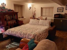 A studio room with a bed and bookshelf at The Old Barn in Hawkshead