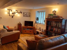 A living room with a television and bookshelf at The Old Barn in Hawkshead