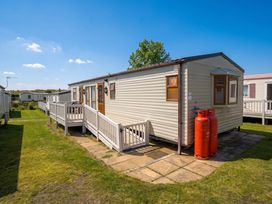 A caravan with steps and gas canisters outside at a campsite