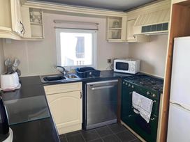 A kitchen with a sink, microwave, oven, and dishwasher at The Old Barn in Manchester