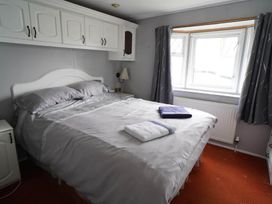 A bedroom with a bed and curtains at The Old Barn in Manchester