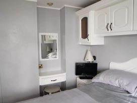A bedroom with a bed, nightstand, lamp, and a television at the property in the location
