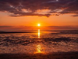 A sunset over the ocean with a ship in the distance at an unknown location
