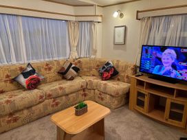 A living room with a sofa and a television at a property near West Mersea
