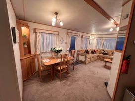 A living room with a table and chairs at a property near West Mersea